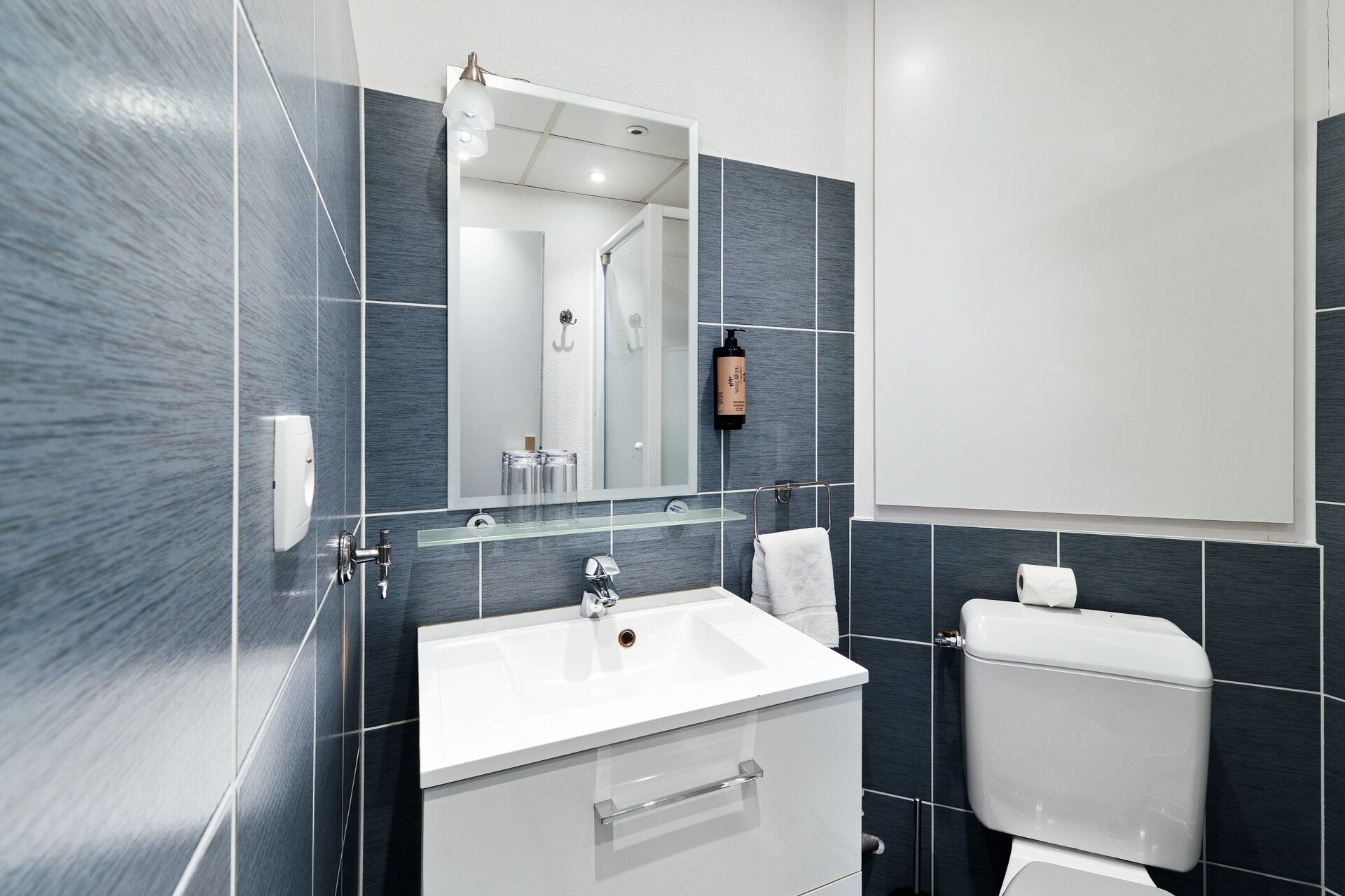 Salle de bain de la chambre simple avec vasque et carrelage bleu, hôtel à Gérardmer