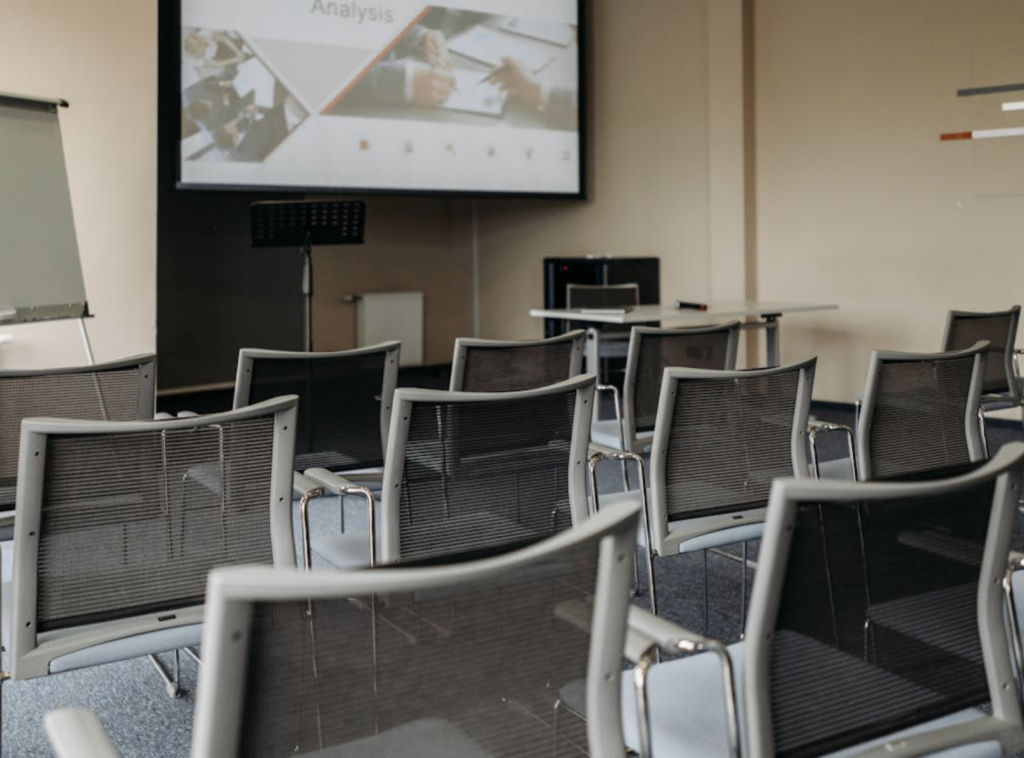 Salle de séminaire équipée d'un écran et de chaises, journée d'étude à l'hôtel La Réserve Gérardmer