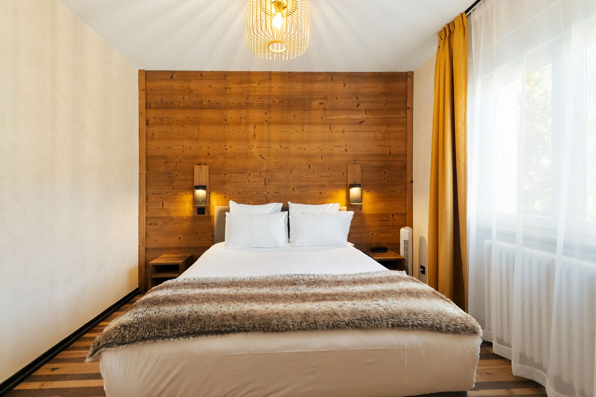 Lit double face à un mur en bois, chambre vue jardin de l'hôtel La Réserve Gérardmer