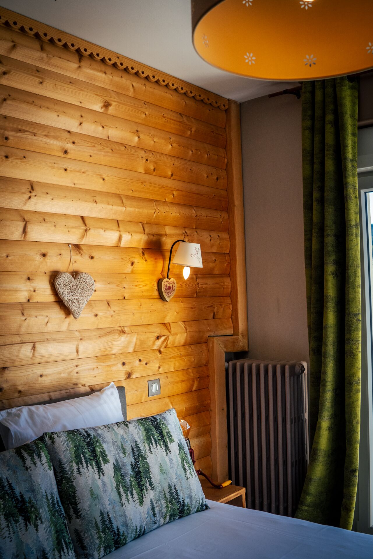 Lit double et mur lambrissé avec cœur en bois, chambre vue lac, hôtel à Gérardmer