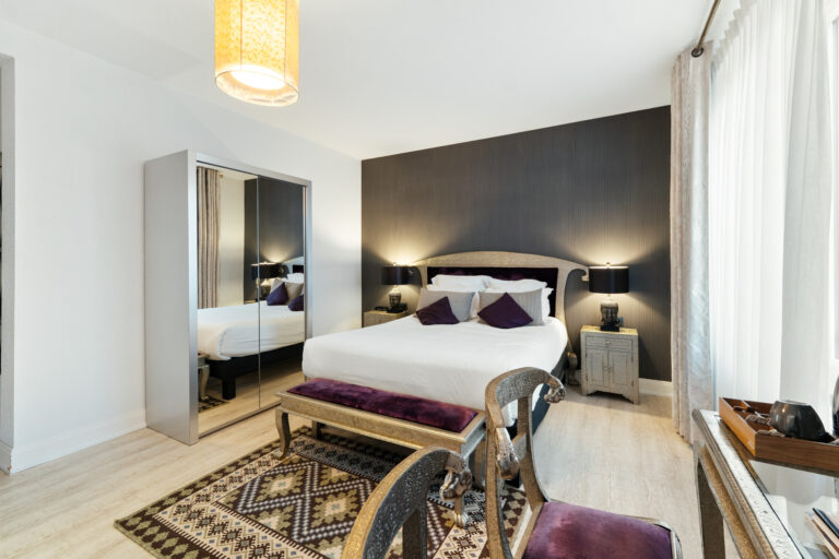 Chambre spacieuse avec lit double, banquette et tapis, hôtel 3 étoiles à Gérardmer