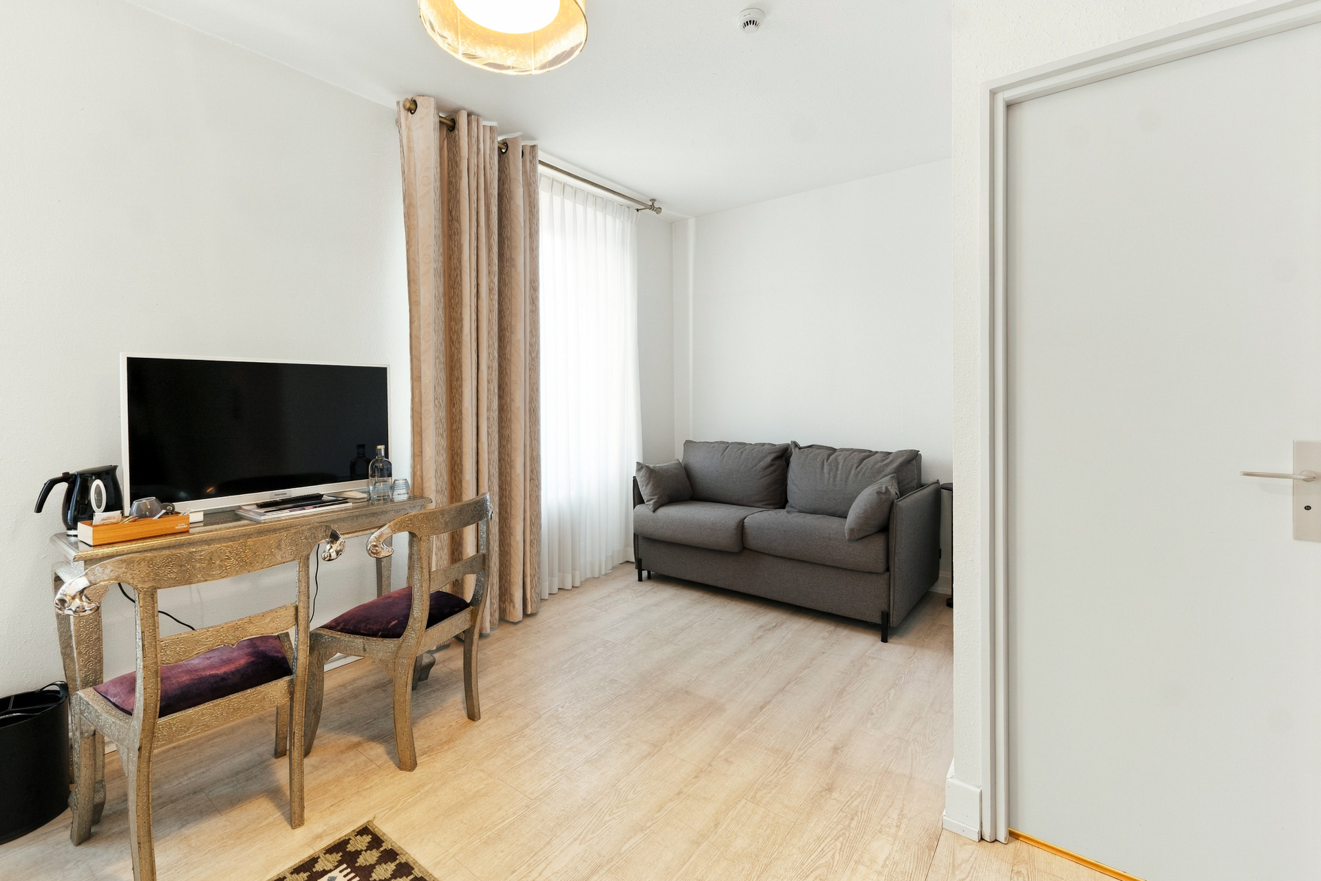 Coin salon avec canapé et bureau, chambre supérieure plus de l'hôtel La Réserve Gérardmer