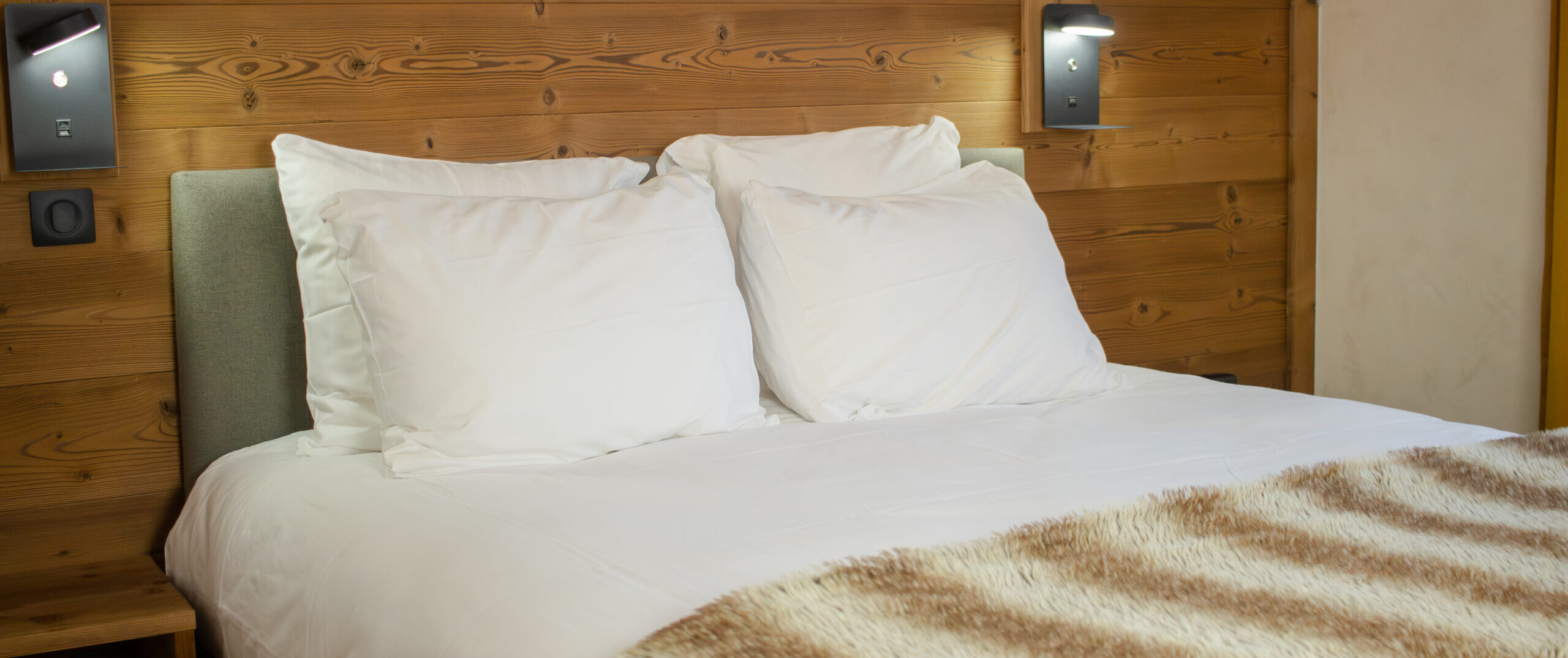 Lit double et tête de lit en bois clair, chambre cocooning de l'hôtel La Réserve à Gérardmer