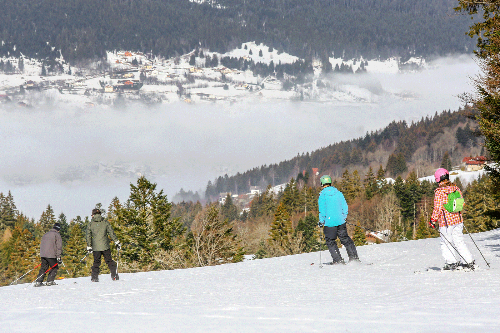 Skieurs sur une piste de la station de ski de Gérardmer, avec vue sur la vallée