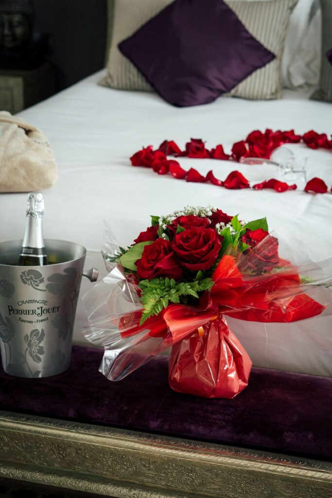 Champagne, roses rouges et pétales sur le lit, séjour romantique à l'hôtel La Réserve Gérardmer