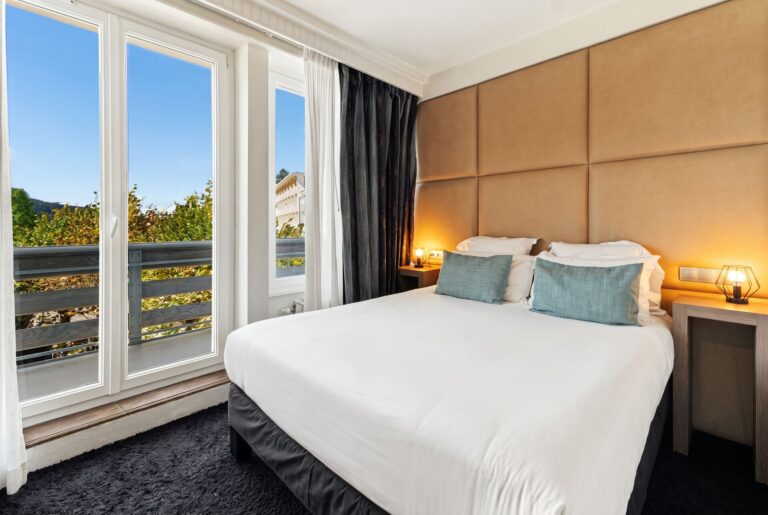 Chambre avec grand lit, tête de lit capitonnée et accès balcon, hôtel La Réserve Gérardmer