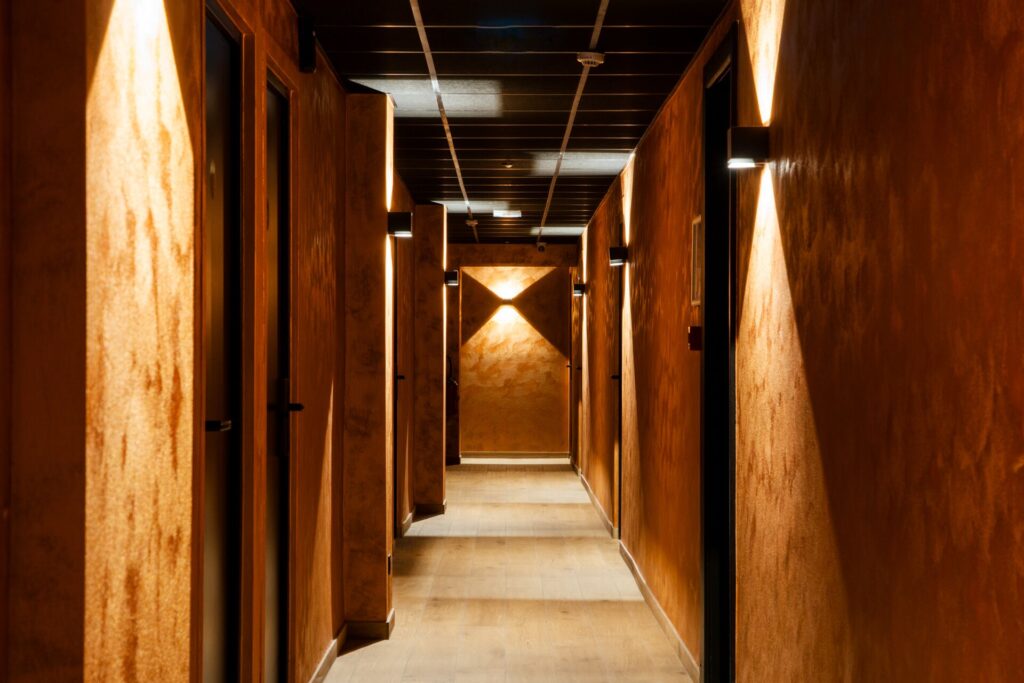 Couloir boisé éclairé menant aux chambres, hôtel La Réserve à Gérardmer
