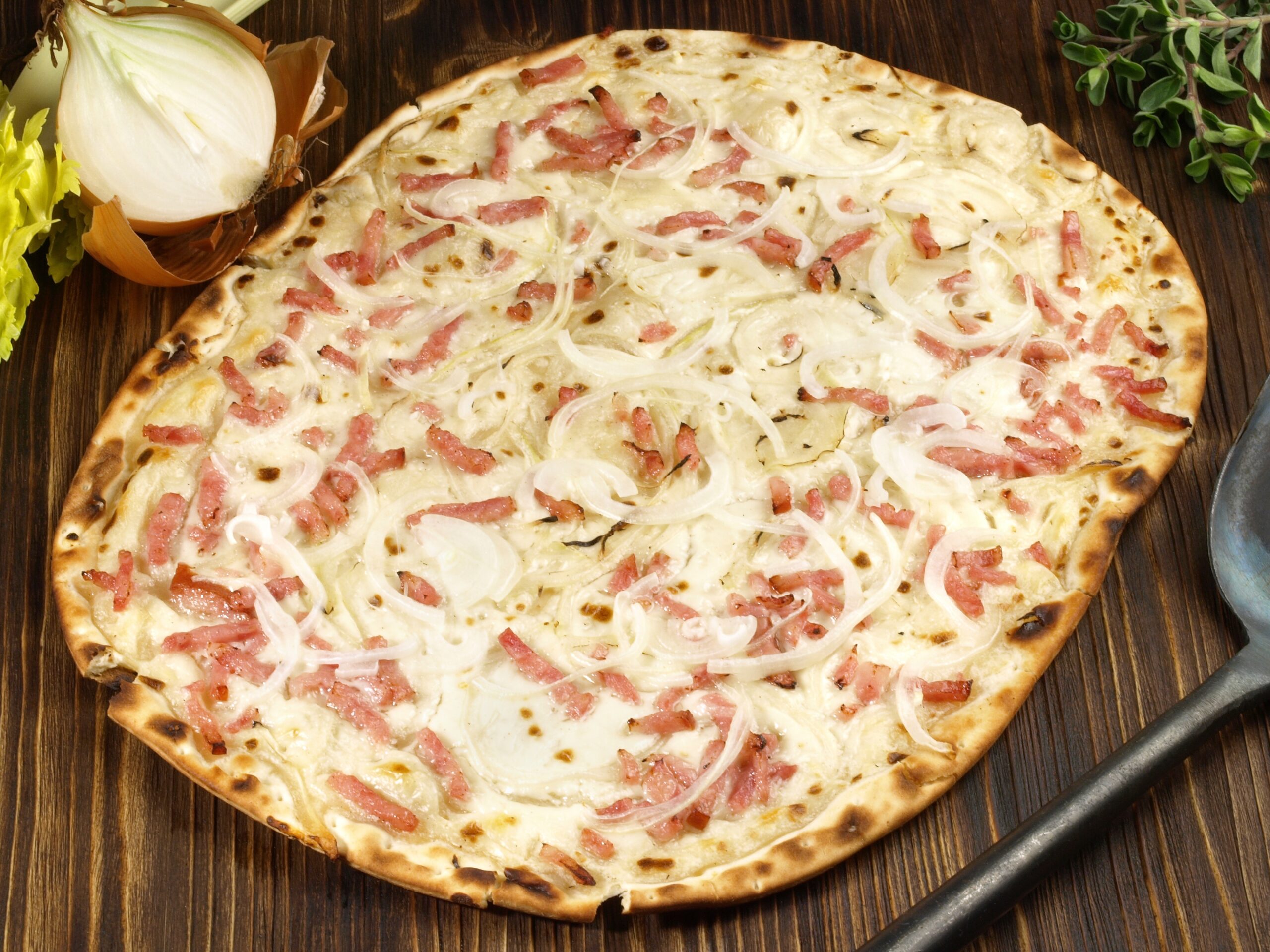 Tarte flambée traditionnelle à la crème fraîche et aux oignons, servie au Lounge Bar de La Réserve à Gérardmer